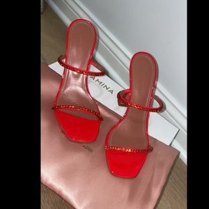 Red metallic leather mules are embellished with tonal crystal trim. Size 38